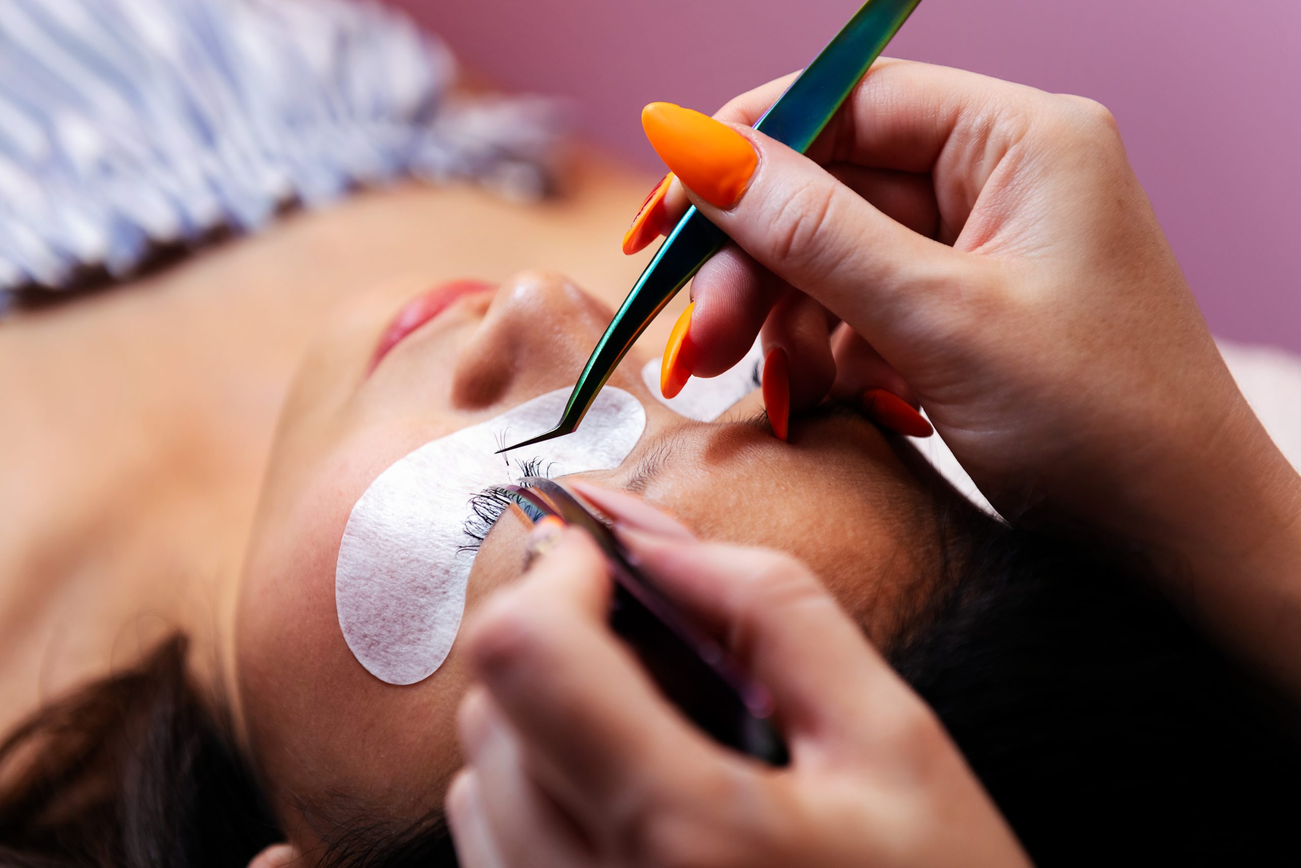 application of eyelash extensions with tweezers, concept of beauty and wellness