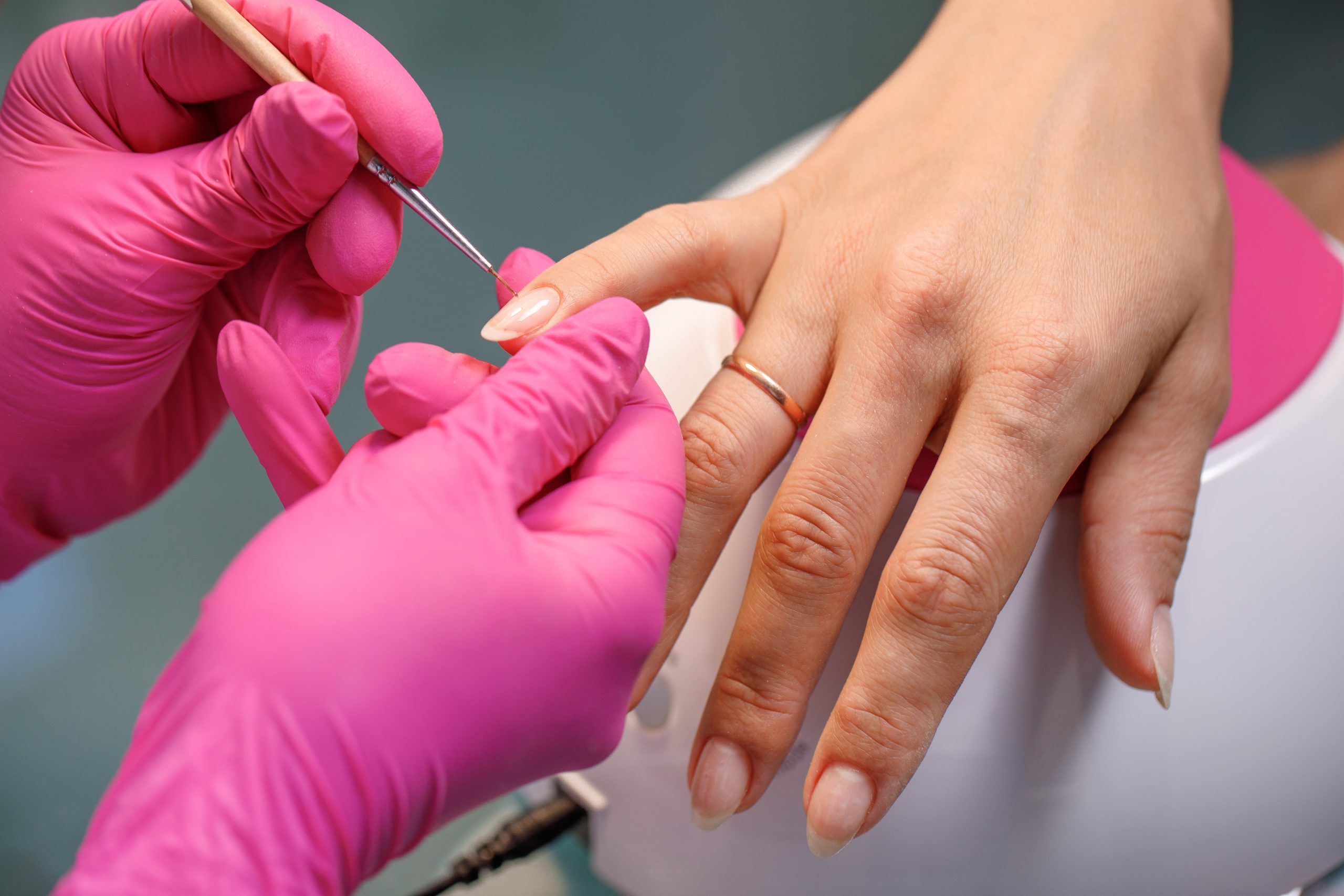 beautician applying Polish nails to woman nails. manicure process